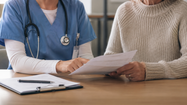 Nurse navigator reviewing care plan with a patient in a hospital consultation room, representing nurse navigator career guide 2026